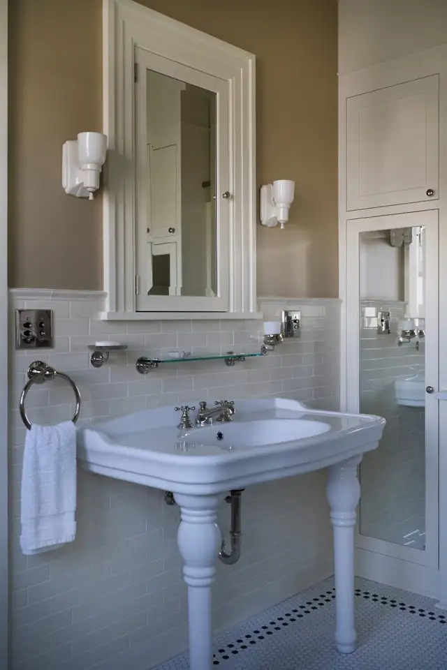 1910 Kings Hill bathroom in Portland with pedestal sink, recessed medicine cabinet, white subway tile and black-and-white mosaic border
