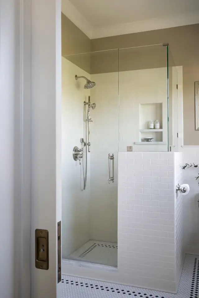 Walk-in shower in a 1910 Kings Hill bathroom in Portland with white subway tile, glass panel and recessed niche