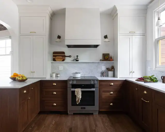 1911 Modern English kitchen in Portland with dark wood lower cabinets, white plaster-style hood and arched doorway