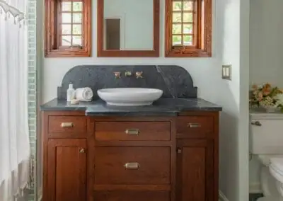 1940 Mt Tabor Tudor bathroom with soapstone vanity top, vessel sink, wood vanity and wood-framed window mirrors