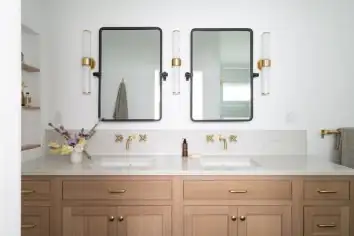 1910 Alameda primary bath in Portland with oak double vanity, brass wall-mount faucets and black framed mirrors