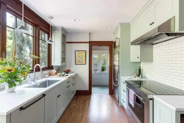 Portland kitchen by Craftsman Design and Renovation with sage cabinets, white subway tile, stained fir window trim and a view through to the dining room